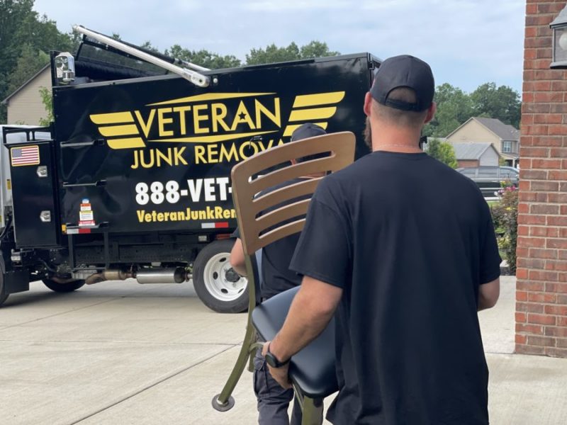 junk removal pro carrying chair to junk removal truck