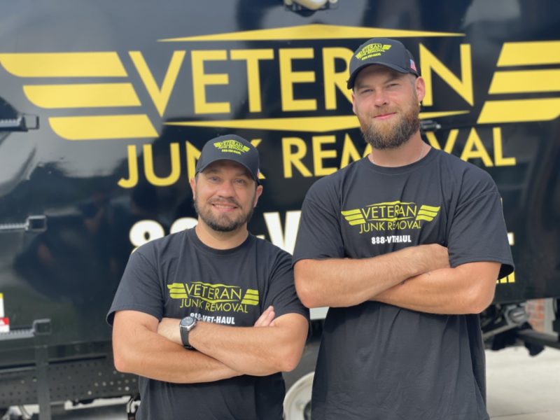 veteran junk removal experts standing in front of junk removal truck